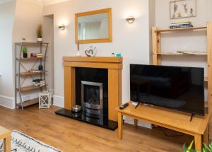sala de estar con chimenea y TV de pantalla plana en Modern Aberdeen City apartment free parking, en Aberdeen