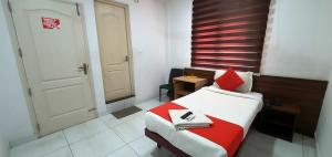 a bedroom with a bed with a red blanket and a door at Kings Fort Rooms Thrippunithura in Ernakulam