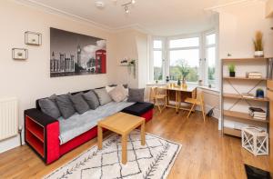 een woonkamer met een bank en een tafel bij Modern Aberdeen City apartment free parking in Aberdeen
