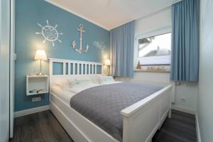 1 dormitorio con 1 cama grande y paredes azules en Badeweg 4 Haus Bullerbü, App 6, en Scharbeutz