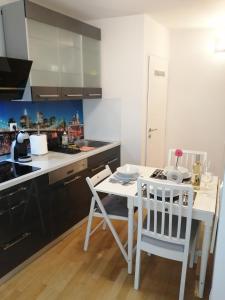 eine Küche mit einem weißen Tisch und 2 Stühlen in der Unterkunft Apartment Tesla in Wien