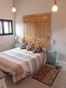 sypialnia z dużym łóżkiem z drewnianym zagłówkiem w obiekcie Casa Iona chalet adosado con vistas a la montaña w mieście Navarredonda de Gredos