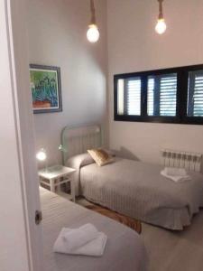 sypialnia z 2 łóżkami i oknem w obiekcie Casa Iona chalet adosado con vistas a la montaña w mieście Navarredonda de Gredos