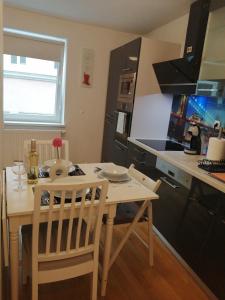 eine Küche mit einem Tisch und Stühlen sowie eine Küche mit einer Theke in der Unterkunft Apartment Tesla in Wien