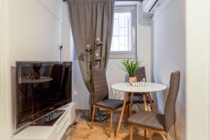 a living room with a table and a tv at Central apartment in the heart of Historic Center in Athens