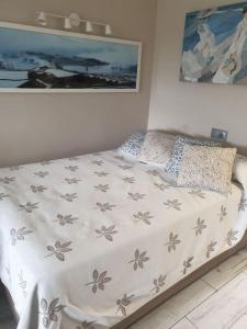 a bed in a bedroom with a bedspread with flowers on it at Precioso estudio con piscina a 200m del mar in Marbella +56 photos