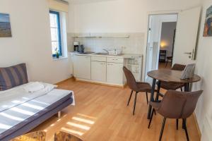 a room with a bed and a table and a kitchen at Ferienanlage Zum Knirk in Lubmin