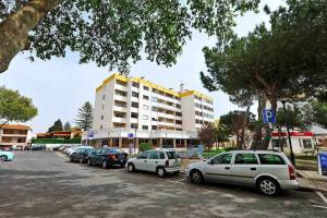 um parque de estacionamento com carros estacionados em frente a um edifício em Prestige Sunset Carcavelos Beach - Checkinhome em Carcavelos