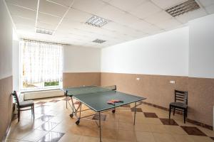 a ping pong table in a room with two chairs at Centrum Halniak in Istebna
