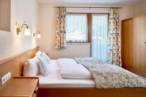 マイヤーホーフェンにあるAppartments Alpinaのベッドルーム1室(大型ベッド1台、窓付)