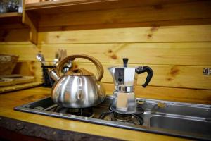 a tea kettle sitting on top of a stove at Orchard retreat off grid shepherds huts in Dorset in Dorchester