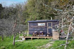 ドーチェスターにあるOrchard retreat off grid shepherds huts in Dorsetのデッキに椅子2脚が備わる小さなキャビン