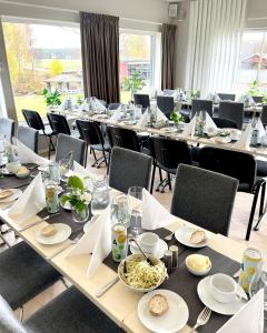 una habitación con mesas largas y sillas con comida. en Hotell Entré Norr, en Umeå