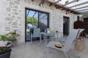 a stone walled patio with a table and chairs at villa on the sea in Ayía Marína