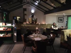 The Swan Inn في Highpeak Junction: مطعم بطاولات وكراسي ورجل يجلس في كونتر