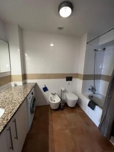 uma casa de banho com 2 WC, um lavatório e uma máquina de lavar roupa em Pérola Azul em Lagos