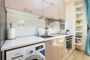 a white kitchen with a sink and a dishwasher at Brand new Central apartment, 10 minutes to Center in Plovdiv