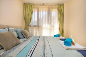 a bedroom with a large bed with blue pillows on it at Brand new Central apartment, 10 minutes to Center in Plovdiv