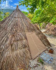 a large straw hut sitting on the beach at Vietnam Surf Camp in Ấp Mỹ Hải