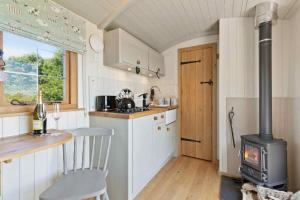 a small kitchen with a stove in a tiny house at Cromwell's Hideaway in Monmouth