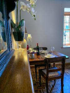 uma mesa de jantar com um vaso e uma cadeira em In De Vines - Chenin - Farmstay em Worcester