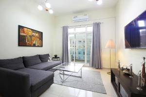 a living room with a couch and a table at Premium Furnished 1 BHK in La Vista 3, Silicon Oasis in Dubai