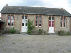 ein Backsteinhaus mit weißen Türen und einem Hof in der Unterkunft Gîte -Belle Maison dans une ancienne école-Tarif réduit hors WE ! in Chanzeaux