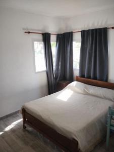 a bedroom with a bed and two windows at CASA DE CAMPO in Helvecia