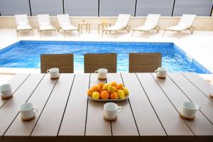 a bowl of fruit on a table in front of a pool at Villa Julija in Rasopasno