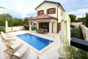 a villa with a swimming pool in front of a house at Villa Julija in Rasopasno
