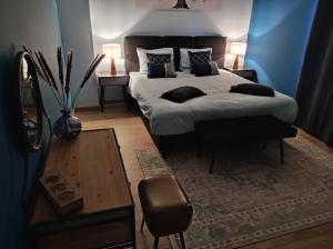 um quarto com uma cama king-size e uma mesa em Gîte La Renéade 