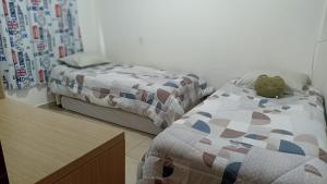 a bedroom with two beds and a teddy bear on the bed at Apartamento amplo e acolhedor, garagem incluída. in Foz do Iguaçu +11 photos