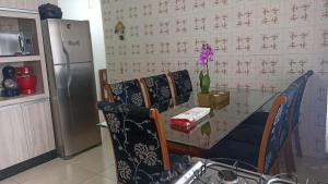 a kitchen with two chairs and a table and a refrigerator at Apartamento amplo e acolhedor, garagem incluída. in Foz do Iguaçu
