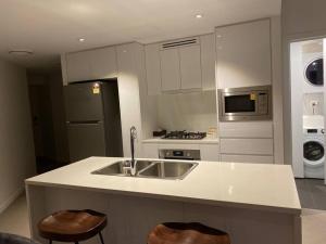 a kitchen with a sink and a stove top oven at New! Great Value - Skytower center of CBD in Brisbane