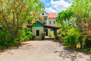 una casa con un jardín con árboles y flores en Maison La Plage by Simply-Seychelles, en Eden Island