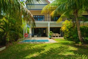 una casa con piscina frente a un patio en Maison La Plage by Simply-Seychelles en Eden Island