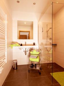 bagno con doccia, lavandino e carrello di LoriVita Residenz Saalbach a Saalbach Hinterglemm