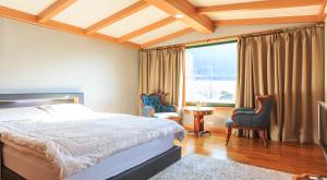 1 dormitorio con 1 cama, 2 sillas y ventana en ChungDam, en Pyeongchang