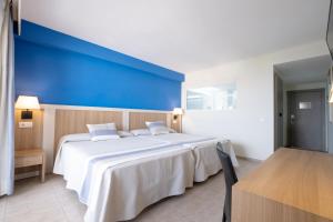 a bedroom with a large bed with a blue wall at Gran Hotel Las Fuentes de Fantasía Hoteles in Alcossebre