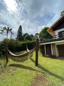 a hammock in a yard next to a house at Chalé Uirapurus in Monte Verde