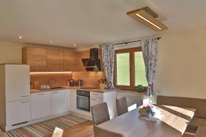 a kitchen with white cabinets and a table with a tableablish at Himmenhof in Tux