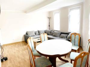 ein Wohnzimmer mit einem Tisch und einem Sofa in der Unterkunft Fully Equipped Flat with *3BR* + *1LR* in Apolda