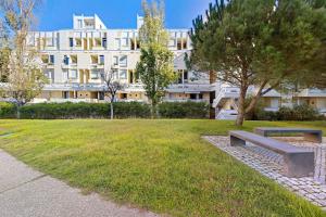 un parc avec un banc devant un bâtiment dans l'établissement Casa de Praia Tróia, à Tróia