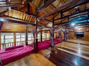 a room with four beds in a room with wooden ceilings at A Sính Homestay in Ha Giang