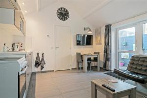 a living room with a kitchen and a table at Hello Zeeland - Vakantiehuis Wijngaardstraat 12 in Domburg