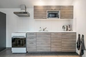 a kitchen with a stove and a microwave at Hello Zeeland - Vakantiehuis Wijngaardstraat 12 in Domburg