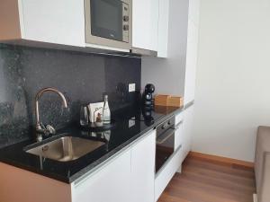 a kitchen with a sink and a microwave at PIMENTA FOUR HOUSE in Amarante