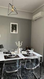 a dining room with a table with plates and chairs at Beautiful apartment next to metro station in Athens