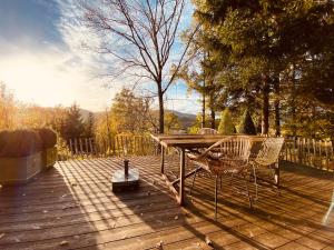 - une table de pique-nique et des chaises sur une terrasse en bois dans l'établissement Le petit ours de Coo, à Stavelot