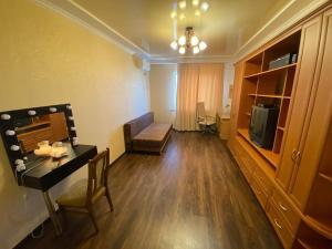een woonkamer met een tafel, een bank en een televisie bij Gagarina Naberegnaya in Dnipro